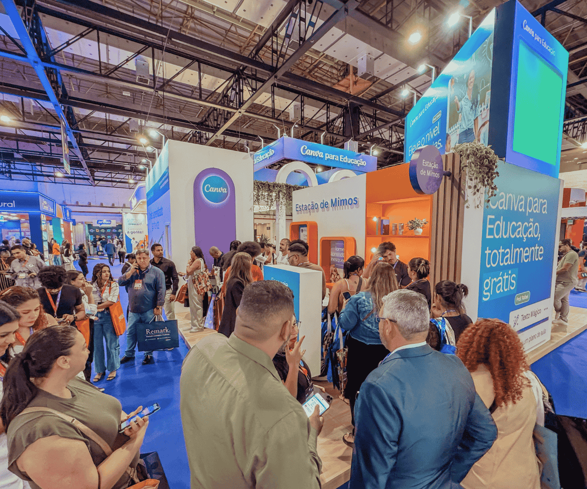 Fila de pessoas em um estande do Canva em evento, indicando resultados do evento corporativo em tempo real.