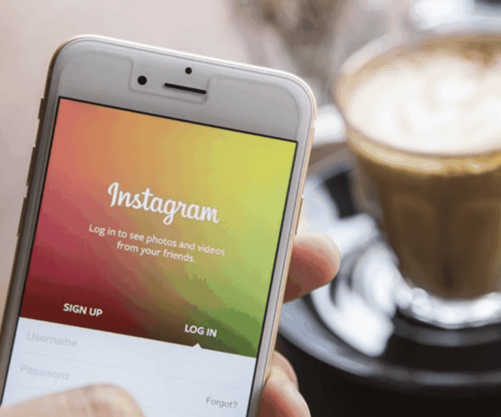 Fotos para artigos antigos (33) base de seguidores no Instagram: pessoa segurando um smartphone com a tela inicial do Instagram aberta.