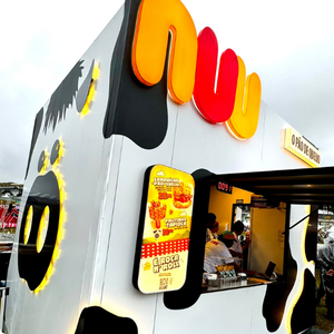 Estande da marca NU no Gramado do LollaBR, com identidade visual marcante, atendimento ao público e experiência gastronômica.